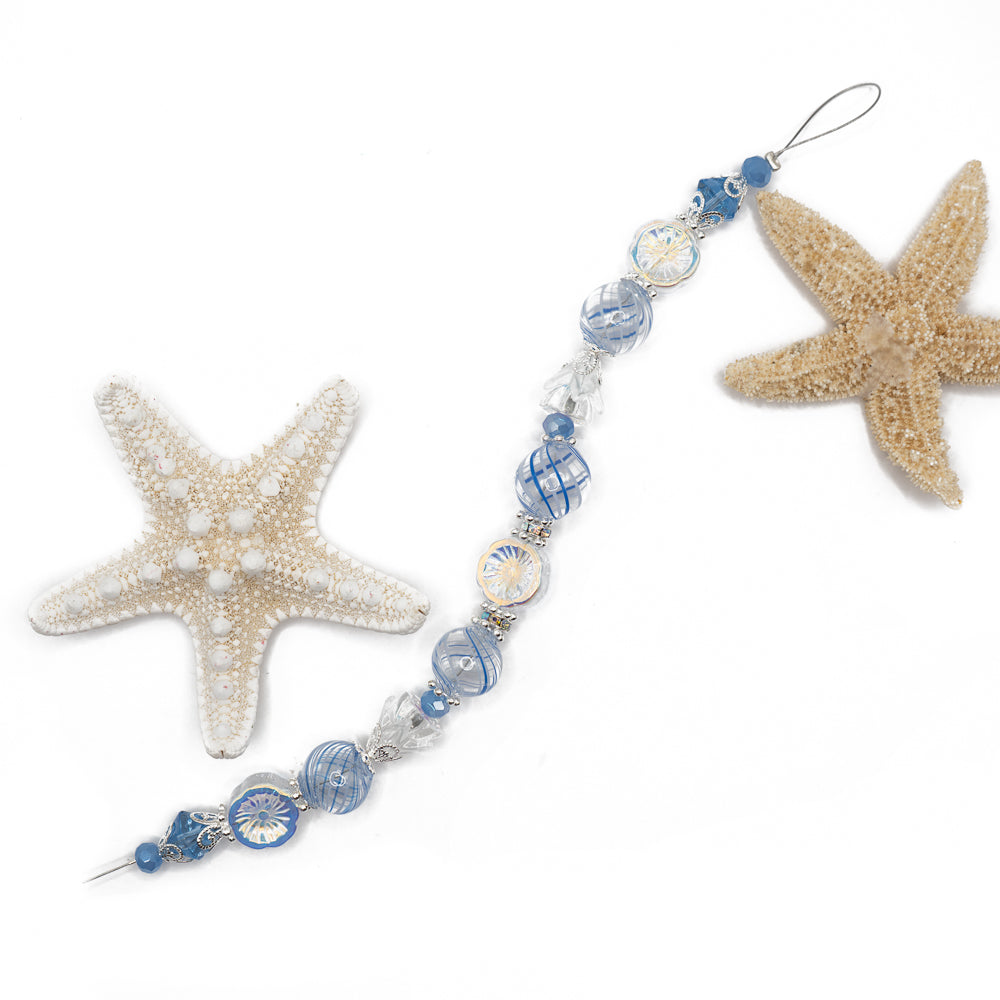 Get ready to sail the seven seas with this stunning glass bead strand. This strand features beautiful striped glass beads, AB glass flowers, faceted glass accents, and silver plated metal caps and bead spacers. This 7 inch bead strand's largest bead measures 14.5mm. Smallest bead on strand measures 6mm.
