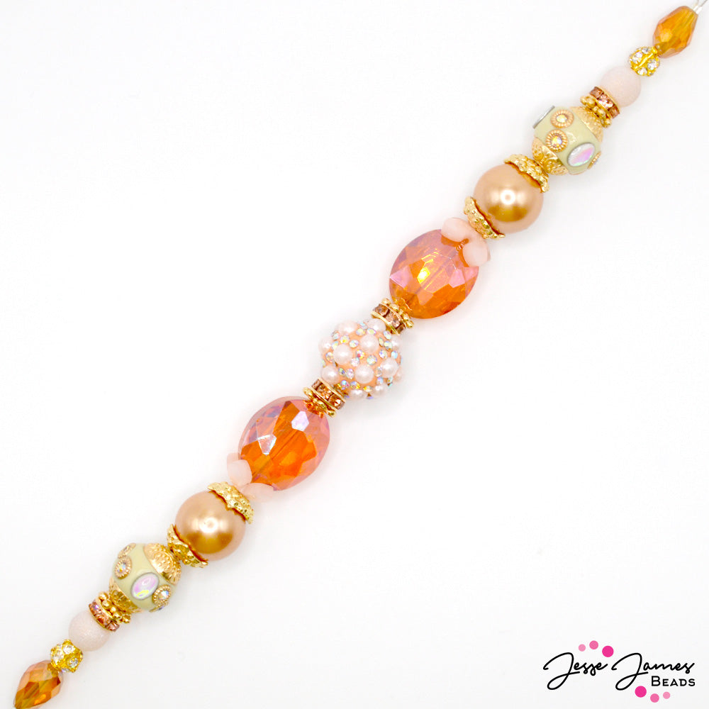 This pastel pink and bright gold bead strand adds a sweet touch to your next stringing or wire-wrapping project. This limited edition 7-inch strand features bohos, custom JJB metal spacers, faceted glass, and sparkling focals. 1 strand per order. Largest bead on strand measures 16mm. Smallest bead on strand measures 4mm.