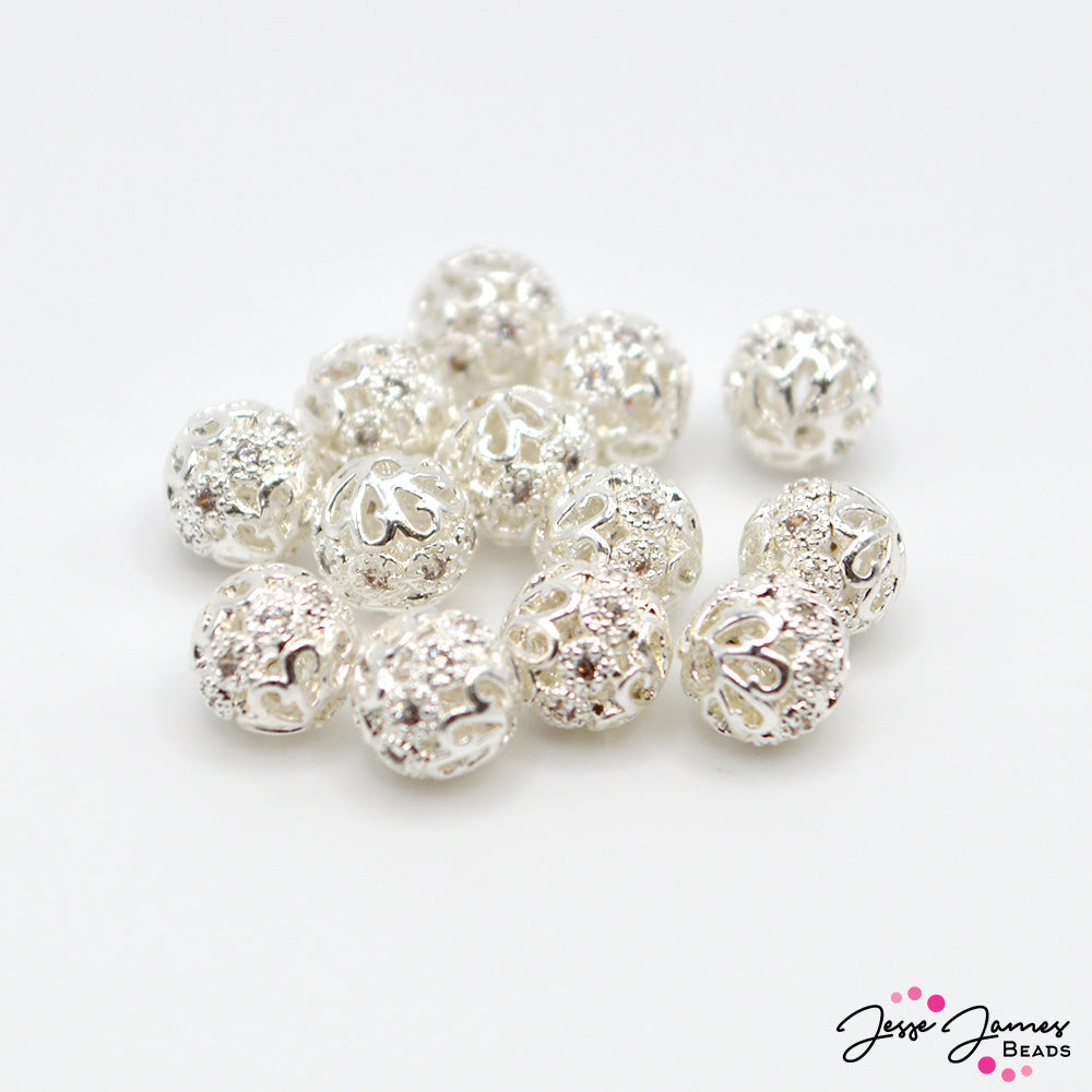 These adorable mini silver ball beads offer a bright silver finish and touch of sparkle to any project. Each piece feature a bright silver color and mini rhinestone center decoration. Each piece measures 6mm. 12 pieces per set.