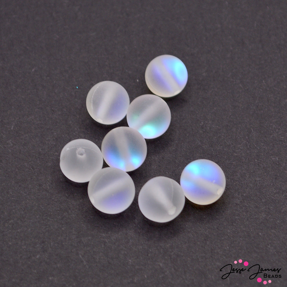 These mini round beads contain an ocean of AB color. Each bead has a semi-opaque finish with a frosty AB sparkle. This one-sided AB finish sparkles in hues of blue and purple when exposed to light. Each set includes 8 round mini beads. Measure 8mm.