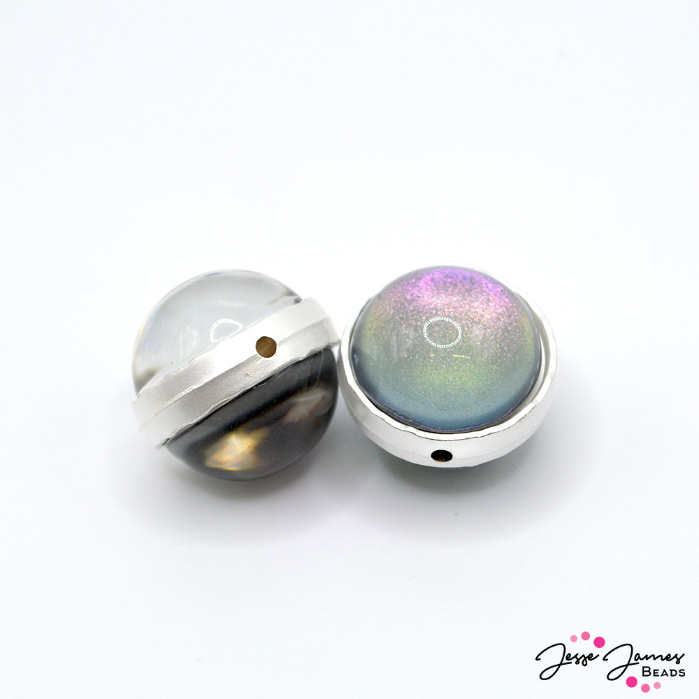 This pearlesque focal pair features a rainbow of AB colored sparkle accented with a dark grey base and bold resin shape. Each large bead make a shimmering focal perfect for bracelets, necklaces, and more. Measure 20mm. 