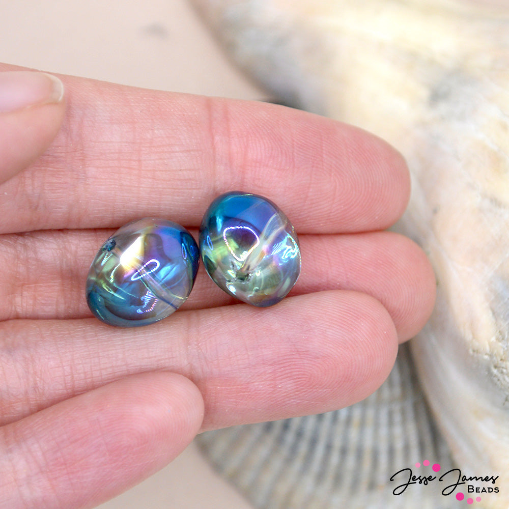 Embrace the magic of the night sky and the ocean's depths with our Bead Set in Blue Jellyfish. Let its aquatic allure transport you to a world of enchantment and beauty. Sold in sets of 8 pieces. Each bead measures 13mm X 11mm. 