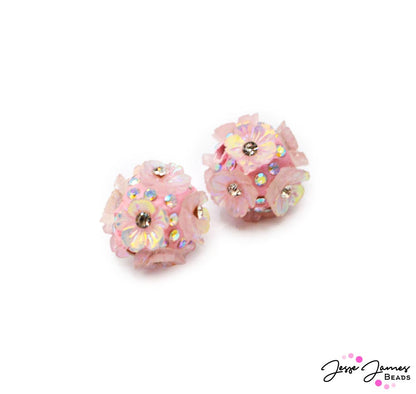 Add a light pink hue to your next jewely creation with this delicate and floral bead pair. Each bead features a floral motif perfect for creating beaded jewelry. Measures 18mm size. Sold in pairs. 