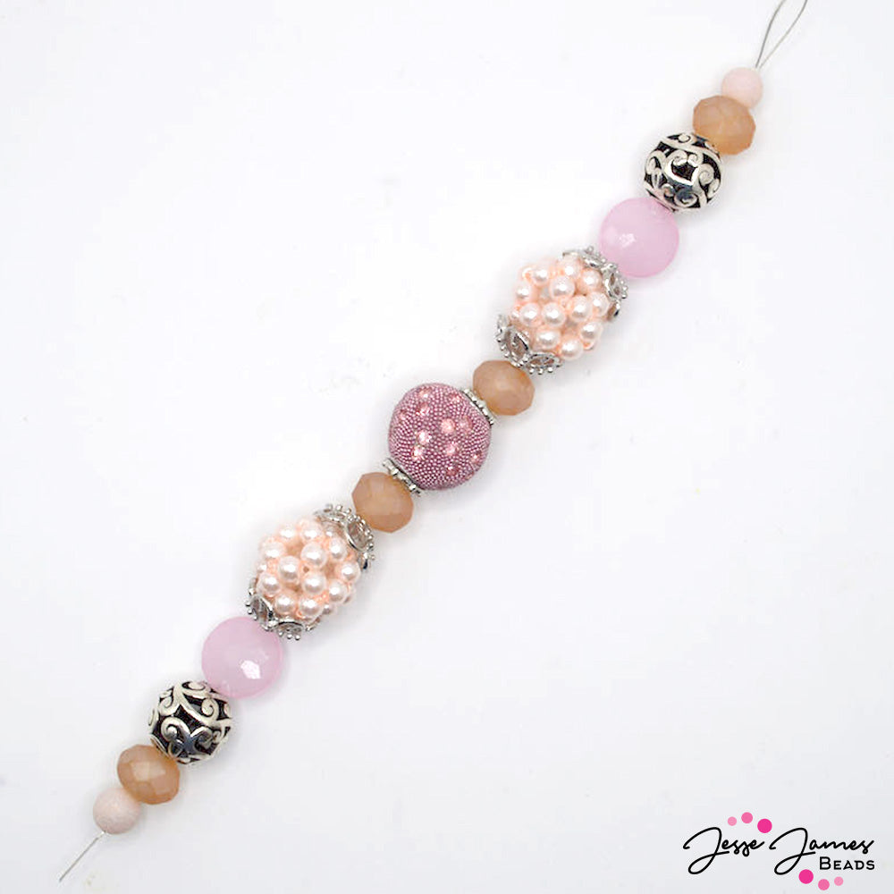 Get dressed up in your best pinks with this sparkling light pink 7 inch bead strand. This strand features rhinestone encrusted boho beads, bubble beaded beads, faceted glass, and silver metal bead caps and spacers. Largest bead on strand measures 18mm. Smallest bead measures 8mm.