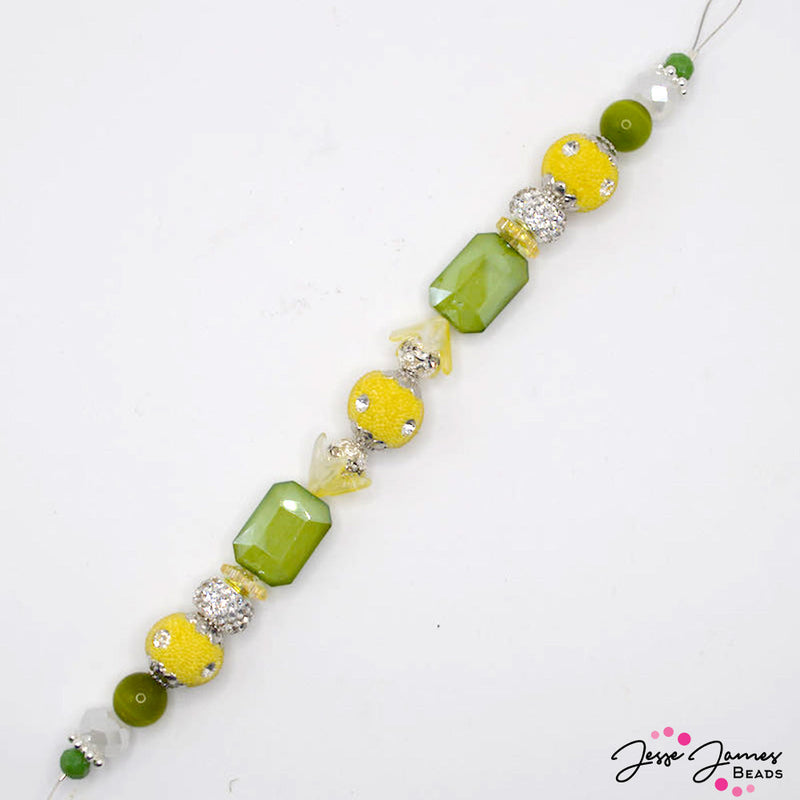 Add a pop of flavor to your next jewelry creation with this bold 7 inch bead strand. Each strand features bohos, faceted glass, and acrylic accents in bright yellow and green hues. Largest bead on strand measures 18mm x 13mm x 8mm. Smallest bead on strand measures 6mm.