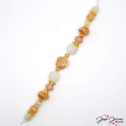 This elegant 7 inch bead strand features bold gold-plated metal accents accented with cream faceted glass and rhinestone accents. Largest bead on strand measures 18mm x 18mm x 8mm. Smallest bead measures 6mm.