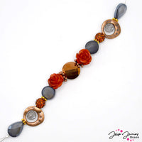 This gorgeous rustic-inspired 7 inch bead strand features a stunning combo of terracotta, grey, and bronze colored beads. Each strand features faceted glass, acrylic roses, bronze metal, and gold-plated metal spacers and accents. Largest bead on strand measures 20mm x 18mm x 8mm. Smallest bead measures 10mm.