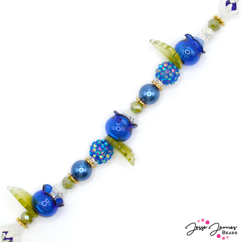 Escape the Winter blues with this blueberry harvest-inspired strand. This tasty, limited edition 7-inch strand features glass bell flowers, leaves, faceted glass, custom JJB metals, and more. 1 strand per order. Largest bead measures 25mm. Smallest bead measures 4mm.