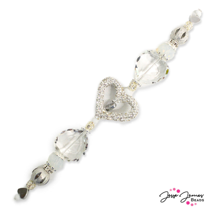 Do you love sparkle? This bead strand is for you! This high sparkle strand features a rhinestone encrusted heart focal paired with large faceted glass hearts, mini metal hearts, milky white rondelles, mini rhinestone balls, mini faceted glass rondelles, rhinestone spacers, and silver metal bead caps. Strand measures 6.75 inches long. Largest bead on strand measures 28mm x 33mm x 5.6mm. The Smallest bead on the strand measures 4mm x 3.5mm.