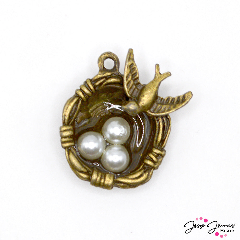 Let your creative spirit take flight with this antique bronze charm. Featuring detailed bird and eggs snuggled in a nest. 1 charm per order. Measures 24mm X 5mm.