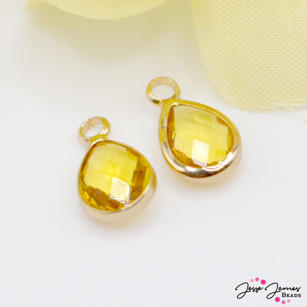 Add a drop of bright lemon flavor with these bright yellow mini charms. Each charm measures 11mm x 6.6mm x 3mm. The inner bail measures 1.5mm. These tiny droplets make perfect Spring-themed accents for earrings, charm bracelets, and more. Each set includes 2 charms